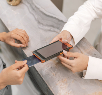 A photo of a woman making a credit card purchase for eyelash products at lash extension salons.