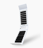 Tiered white tray containing multiple rows of black Xtreme Lashes Omni Volume lash extensions organized by length, ready for application.